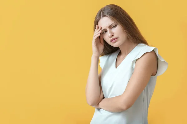 Stressed young woman on color background