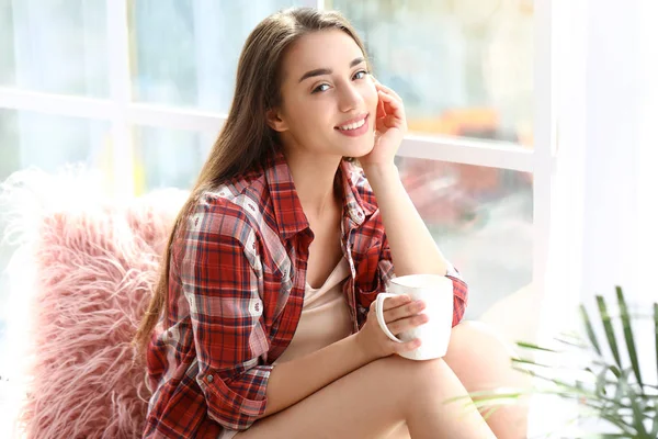 Morning of beautiful young woman drinking coffee near window — Stock Photo, Image