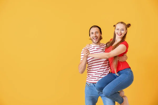 Cool pareja joven bailando contra el fondo de color — Foto de Stock