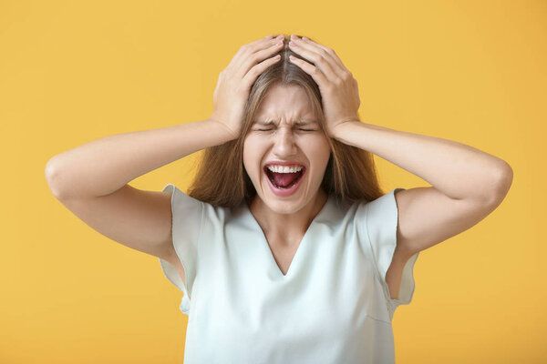 Stressed young woman on color background