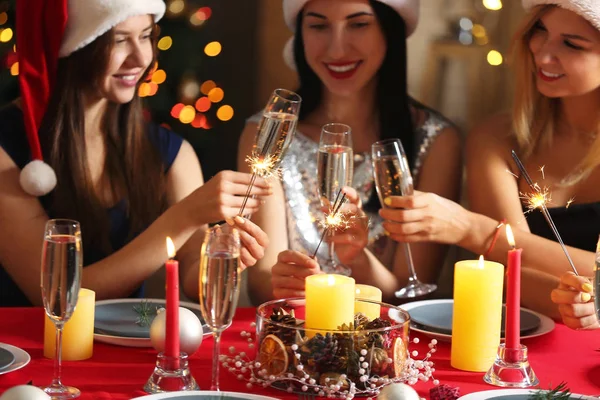 Χαρούμενες γυναίκες με χριστουγεννιάτικα βεγγαλικά και ποτήρια σαμπάνιας στο πάρτι — Φωτογραφία Αρχείου