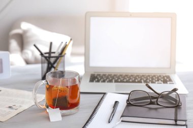 Masada sıcak çay, dizüstü bilgisayar ve kırtasiye ile Fincan