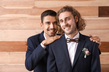 Ahşap arka plan karşı düğün gününde mutlu eşcinsel çiftin Portresi