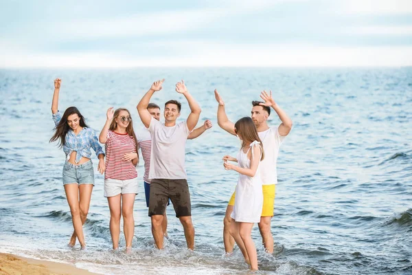 Felices amigos en la playa del mar en el resort —  Fotos de Stock