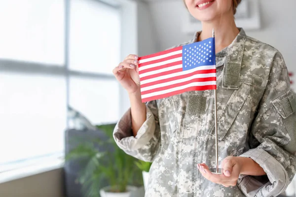 Young female soldier with USA flag in headquarters building — Stock Photo, Image