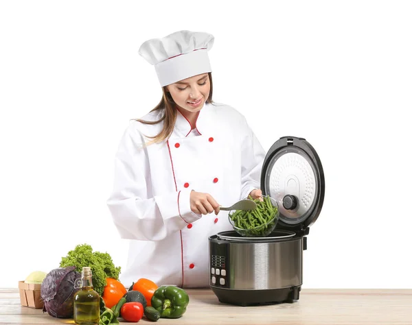Женщина шеф-повар с помощью современной мульти-плита на белом фоне — стоковое фото