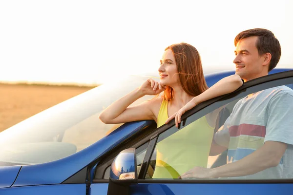 Happy couple with their new car in countryside — Stock Photo, Image