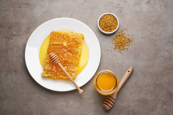 Összetétele a szürke háttér édes mézzel — Stock Fotó