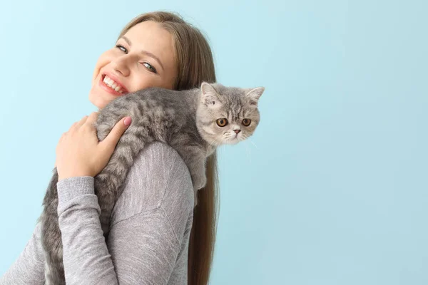 Красивая молодая женщина с милым котом на цветном фоне — стоковое фото