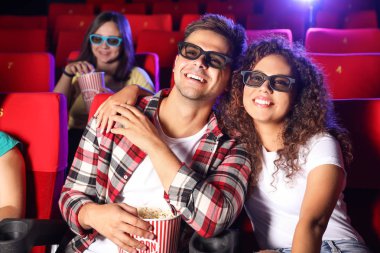 Patlamış mısırlı çift sinemada film izliyor.