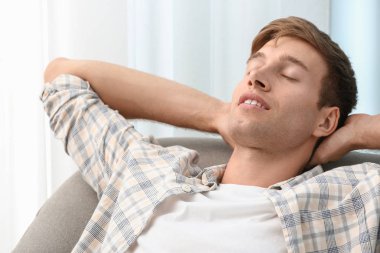 Yakışıklı genç adam evde dinleniyor.