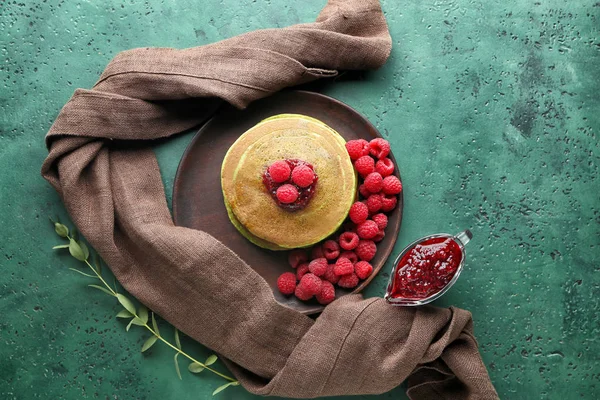 Teller mit grünen Pfannkuchen und Himbeermarmelade auf dem Tisch — Stockfoto