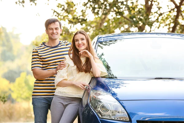 Couple heureux près de leur nouvelle voiture à l'extérieur — Photo