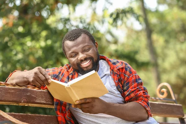 Africano-americano homem leitura livro no parque — Fotografia de Stock