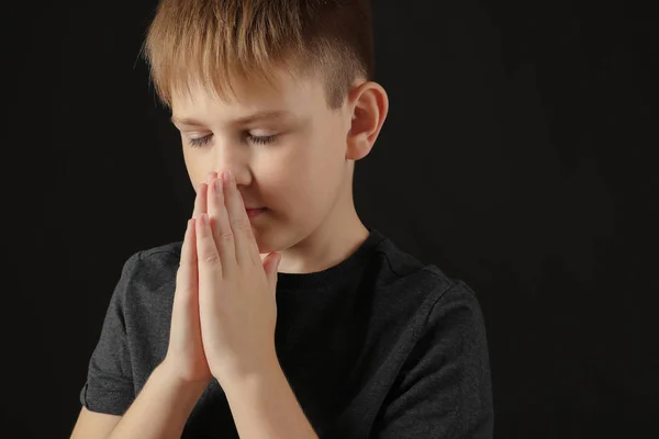 Praying little boy on dark background — Stock Photo, Image