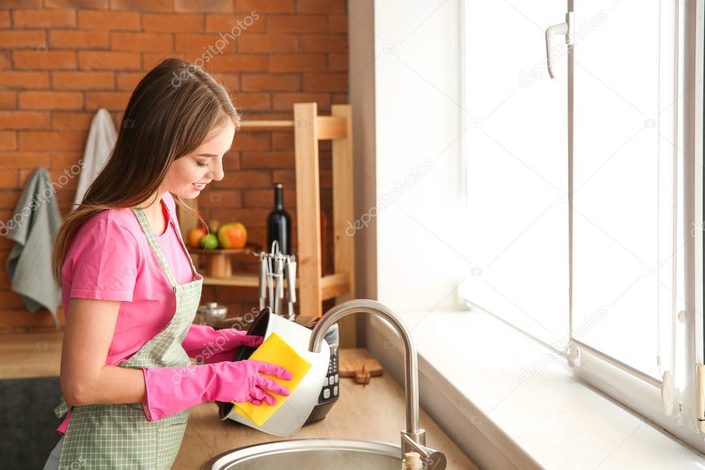 Woman washing modern multi cooker in kitchen