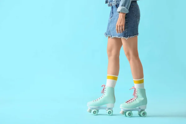 Belle jeune femme sur patins à roulettes sur fond de couleur — Photo