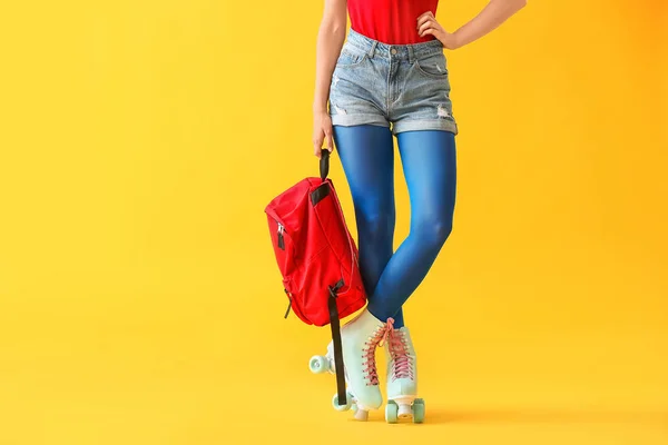 Belle jeune femme sur patins à roulettes sur fond de couleur — Photo