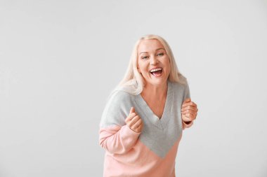 Gri arka planda mutlu olgun kadın