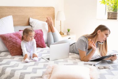 Evde yatak odasında kızı ile çalışan anne