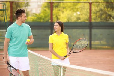 Genç çift tenis kortunda oynamaya