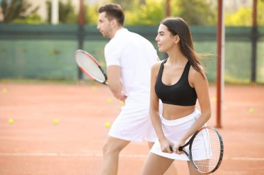 Genç çift tenis kortunda oynamaya
