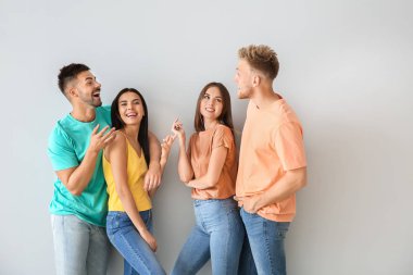 Hafif arka planda şık rahat giysiler içinde gençlerin grubu