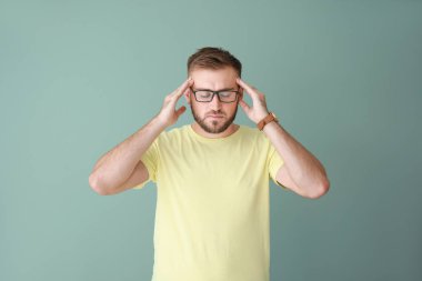 Renkli arka planda stresli genç bir adam