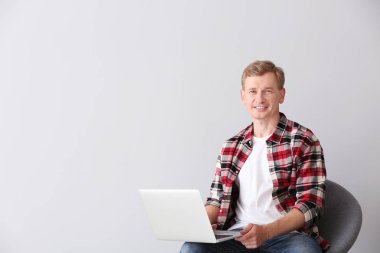 Hafif arka planda dizüstü bilgisayar ile yakışıklı adam Portresi