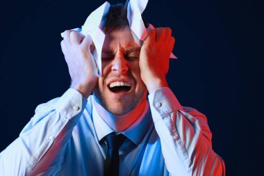 Koyu zemin üzerinde buruşturulmuş kağıt ile kızgın işadamı portresi