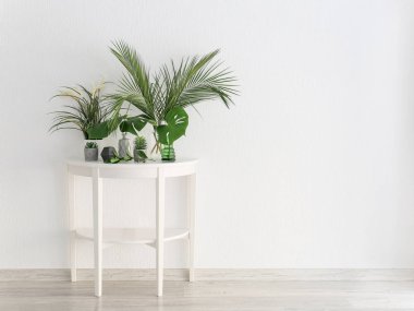 Beyaz duvara yakın çiçek dekorlu masa