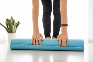 Genç sportif kadın evde yoga mat unrolling