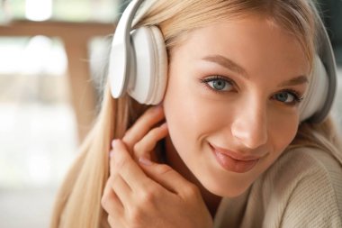 Evde müzik dinleyen güzel genç bir kadın.