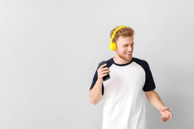 Yakışıklı genç adam arka planda müzik dinliyor.