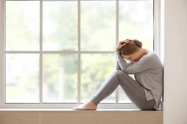 Woman having panic attack near window