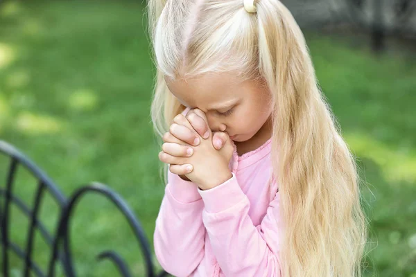 Cute little girl praying outdoors — Stock Photo, Image