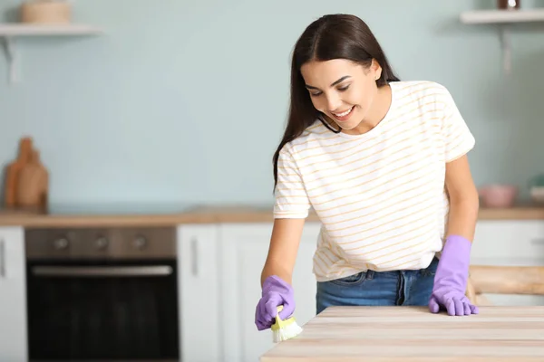 Woman cleaning table in kitchen — Stock Photo, Image