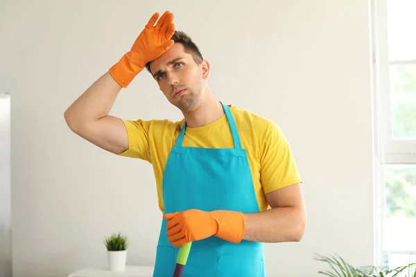 Vermoeide jonge man schoonmaak keuken — Stockfoto