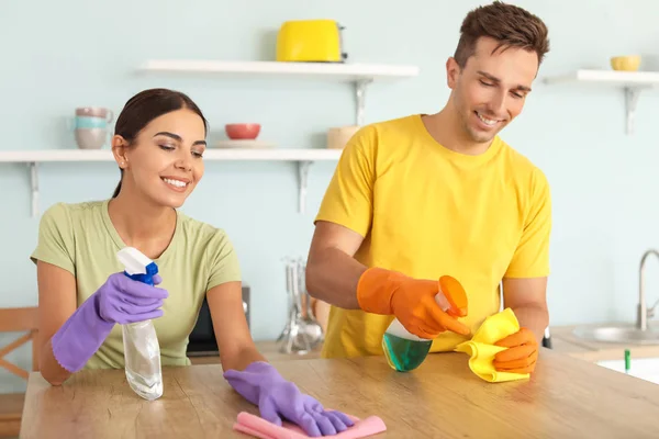 Jovem casal limpeza cozinha juntos — Fotografia de Stock