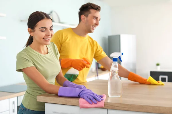 Jovem casal limpeza cozinha juntos — Fotografia de Stock