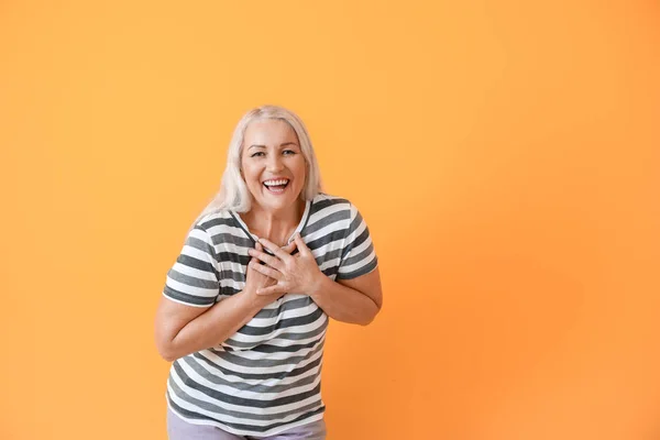 Gelukkig volwassen vrouw op kleur achtergrond — Stockfoto