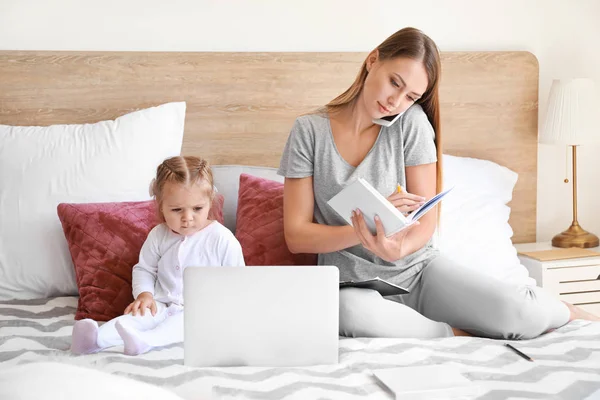 Working mother with her daughter  in bedroom at home