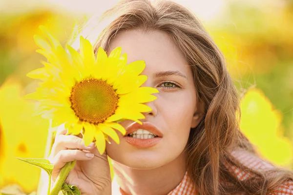 Beautiful young woman in sunflower field on summer day — Stock Photo, Image