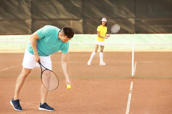 Young couple playing tennis on court — Stock Photo, Image