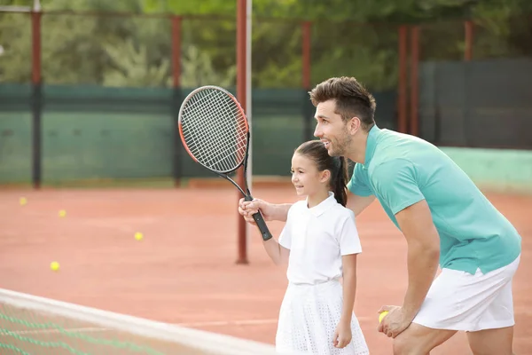 Mała dziewczynka i jej ojciec gra w tenisa na dworze — Zdjęcie stockowe