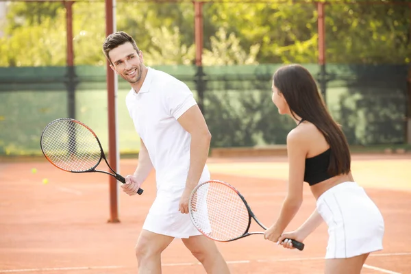 Young couple playing tennis on court — Stock Photo, Image