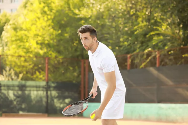 Młody człowiek, grać w tenisa na korcie — Zdjęcie stockowe