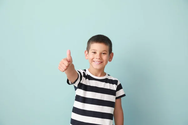 Portrait of happy little boy showing thumb-up gesture on color background — Stock Photo, Image