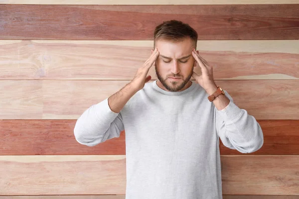 Stressed young man on wooden background