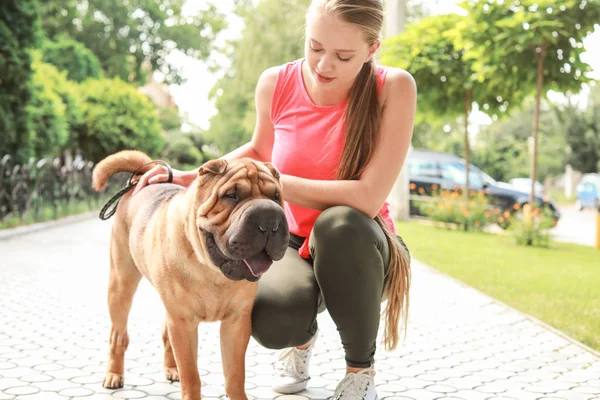 Sporty woman with cute dog walking outdoors — Stock Photo, Image